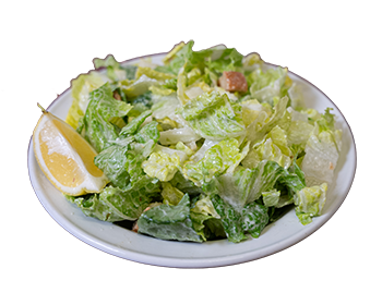 plate of green romaine lettuce, cruttons, in a caesar salad dressing, and a wedge of lemon slice.